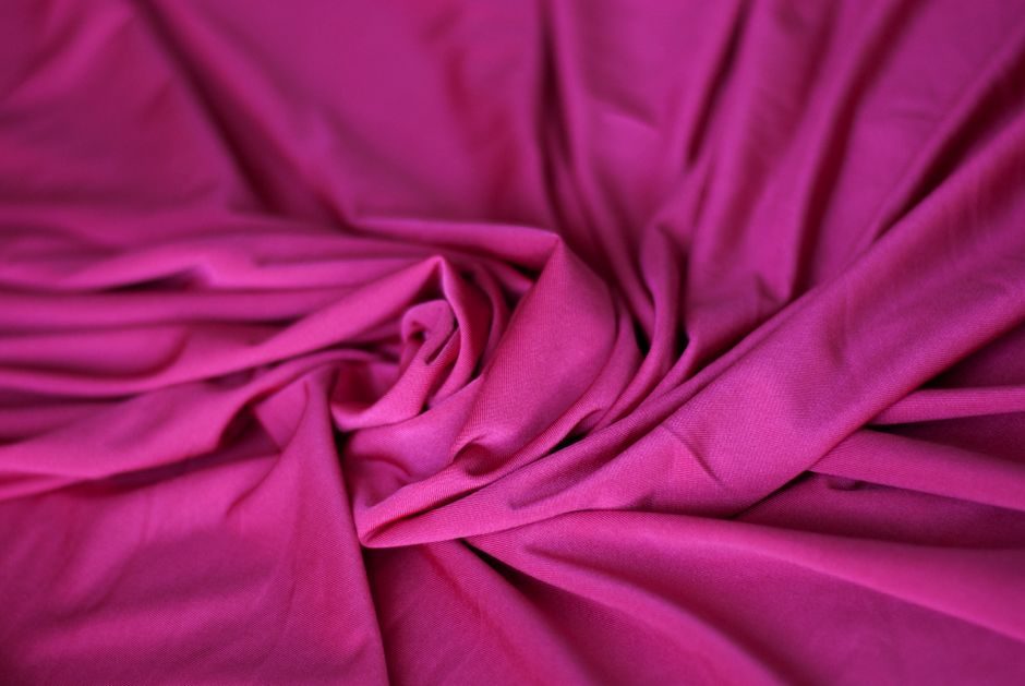 赪紫 — A detailed close-up of vibrant pink fabric with soft wrinkles and a silk-like texture.