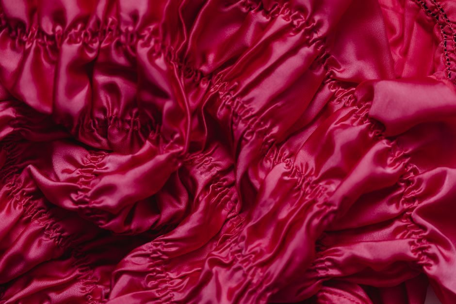 大繎 — Close-up of vibrant red silk fabric showing elegant folds and luxurious texture.
