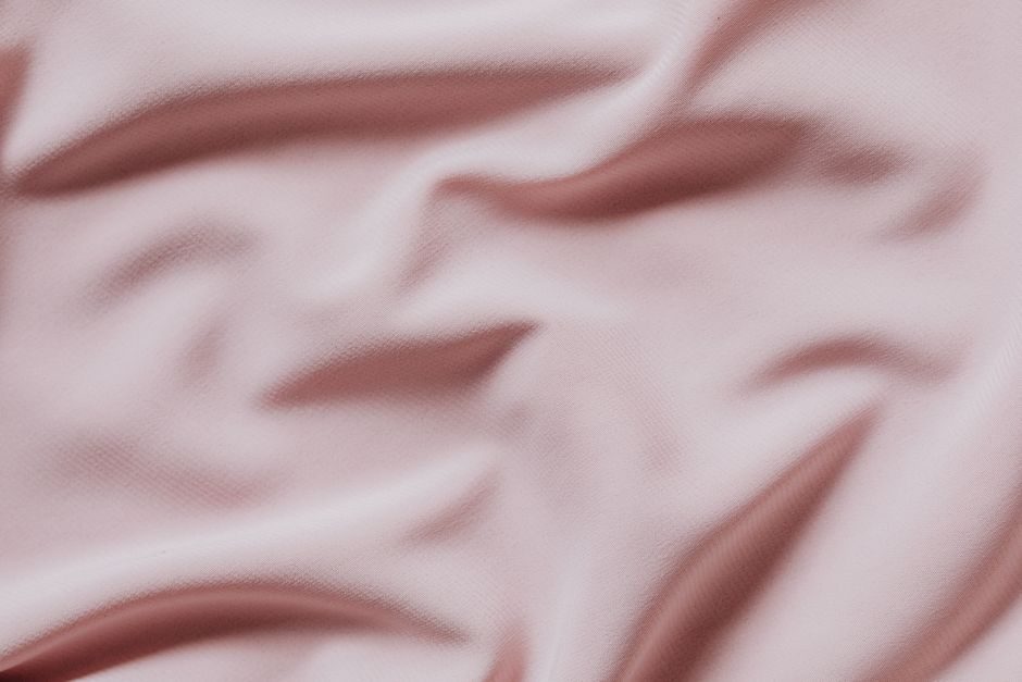 粉米 — Elegant soft pink fabric with textured surface, perfect for design backgrounds and textiles.