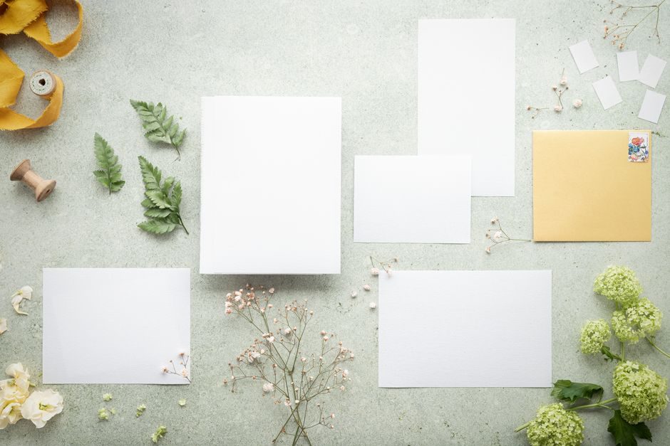 葭菼 — Top view of stationery set with flowers and leaves on a gray background, perfect for creative projects.