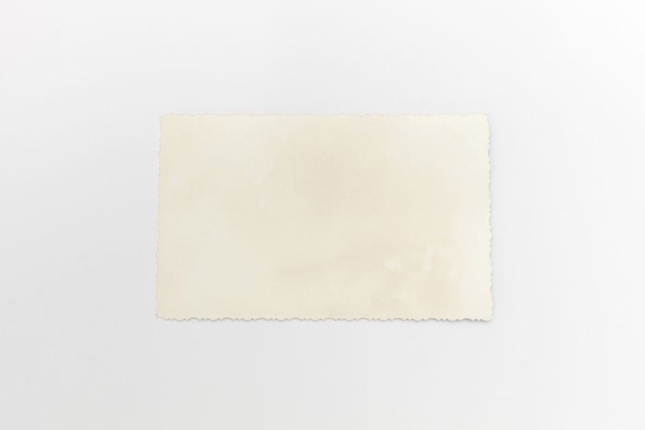 皦玉 — Close-up of a vintage blank paper on a white background with textured edges, ideal for retro designs.