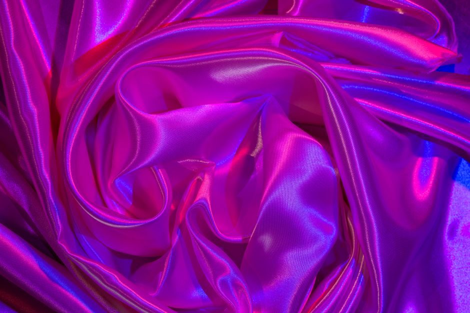 齐紫 — A vivid satin fabric in purple and pink hues showcases intricate folds and shimmering texture.